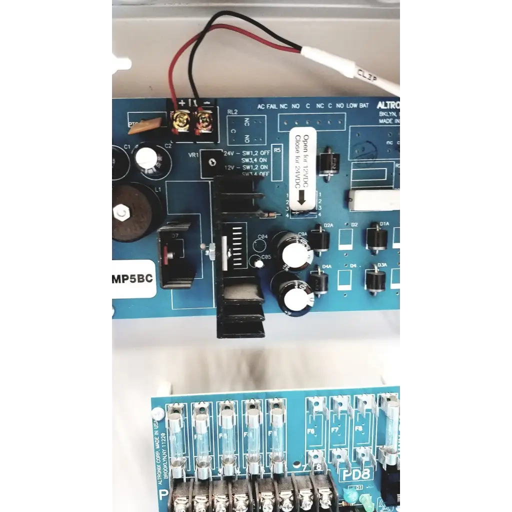 Blue circuit board of altronix smp5ctx power supply with black and white components for 12VDC or 24VDC charging