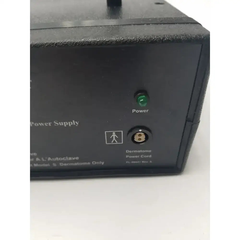 Black integra padgett model s electric dermatome power supply showing green power light and circular power card input port
