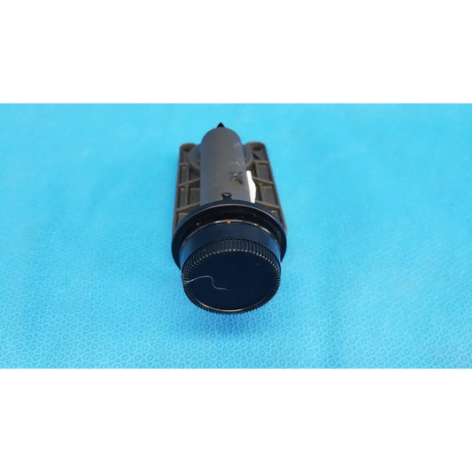 Black cylindrical flashlight with textured grip and matte finish used as focus drive for porro prism lens barrel assembly
