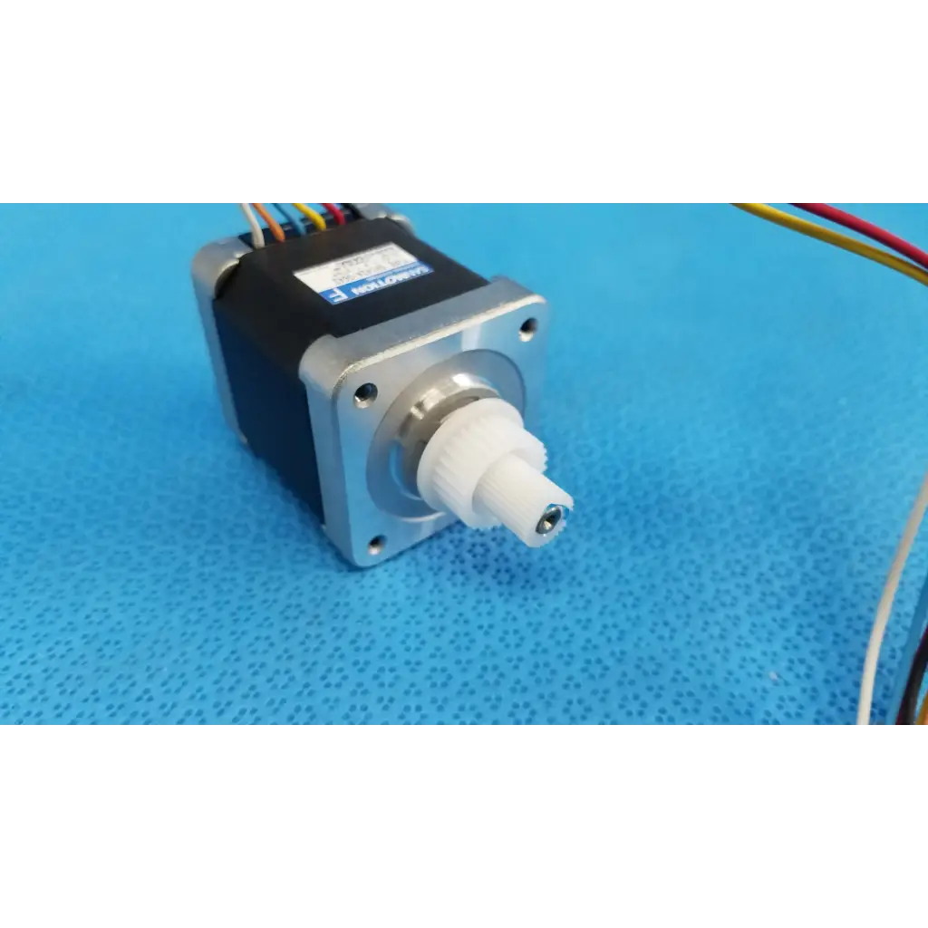 Black and silver internal sanyo denki stepper motor with white plastic gear shaft and multicolored wires for topcon trc-nw8 fundus camera