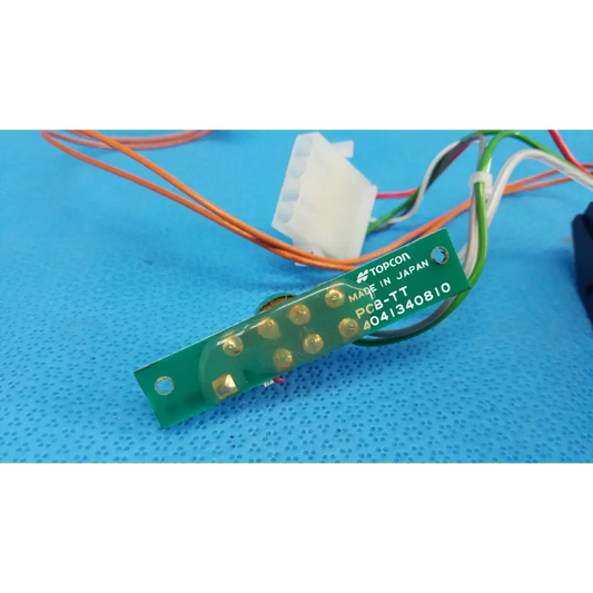 Green rectangular circuit board with gold solder points marked pcb-tt for trc-nw6s harness assembly by topcon