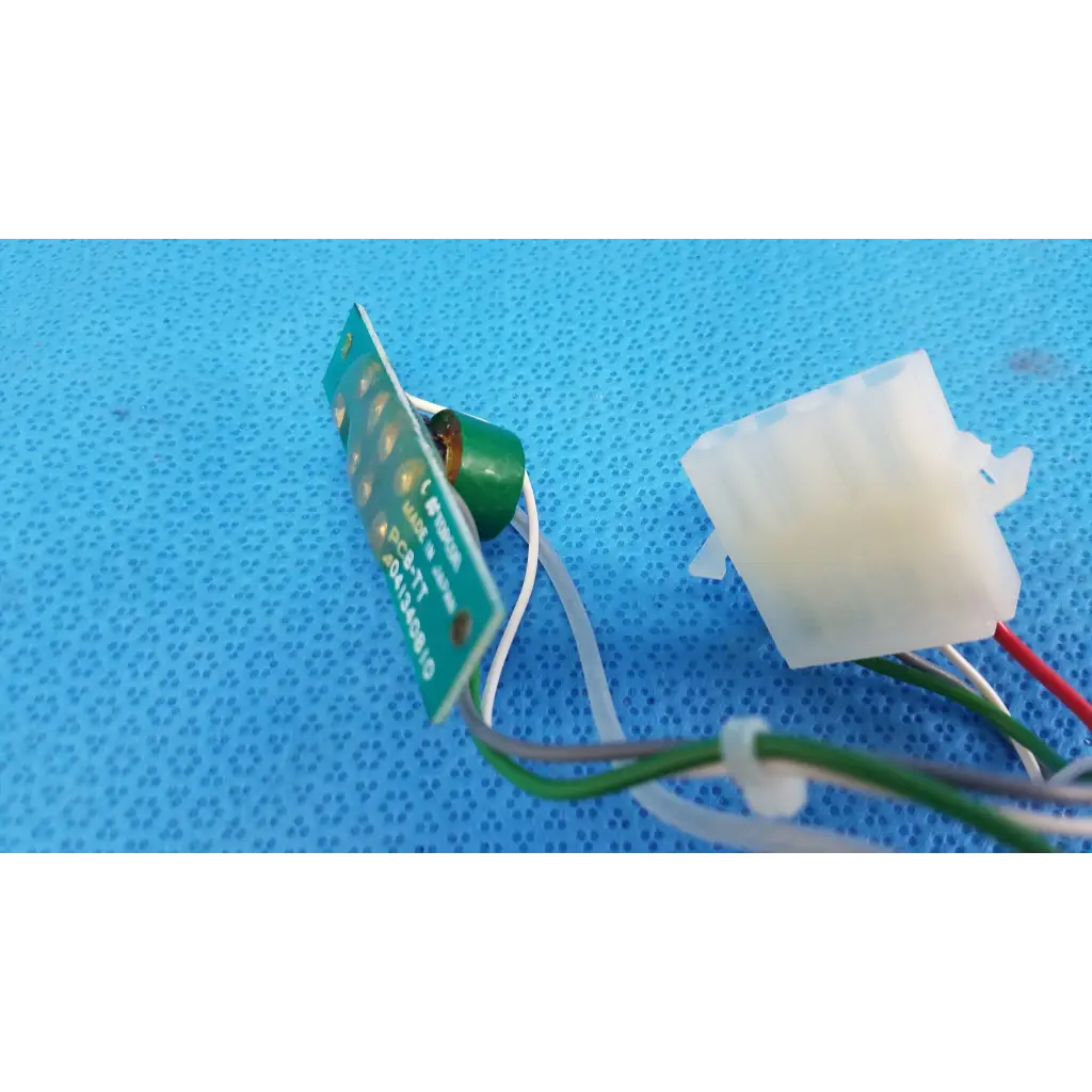 Green circuit board harness assembly with white and red wires connected to a translucent connector for trc-nw6s retinal camera