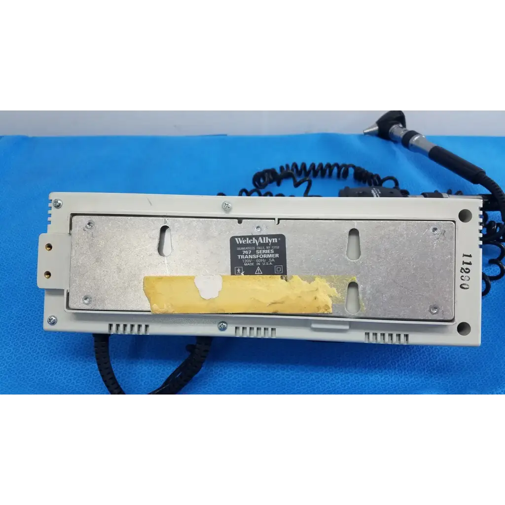 Beige welch allyn 103 series wall transformer with metallic backplate and yellow tape on label for ophthalmoscope use