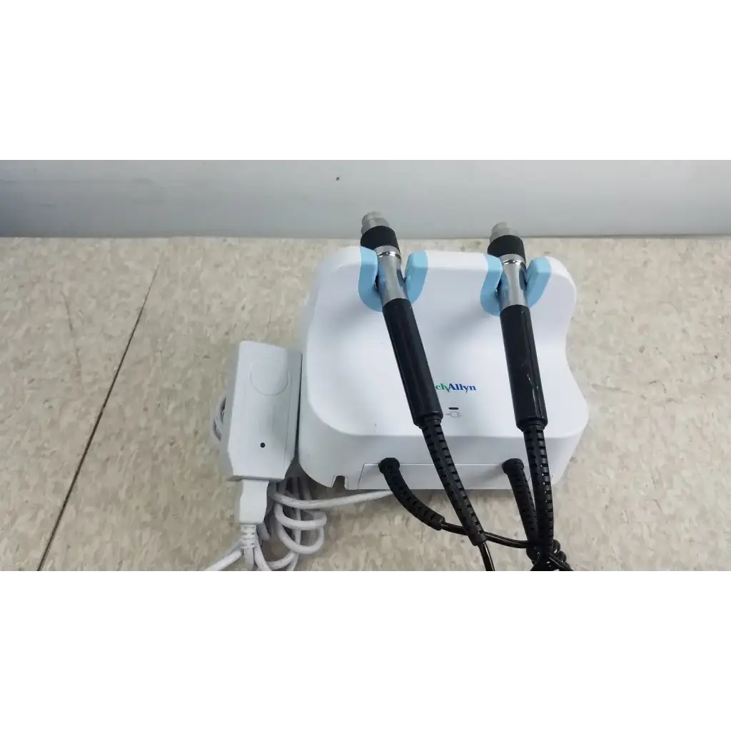 White plastic base with two black-handled light blue dental handpieces attached to welch allyn wall transformer integrated system