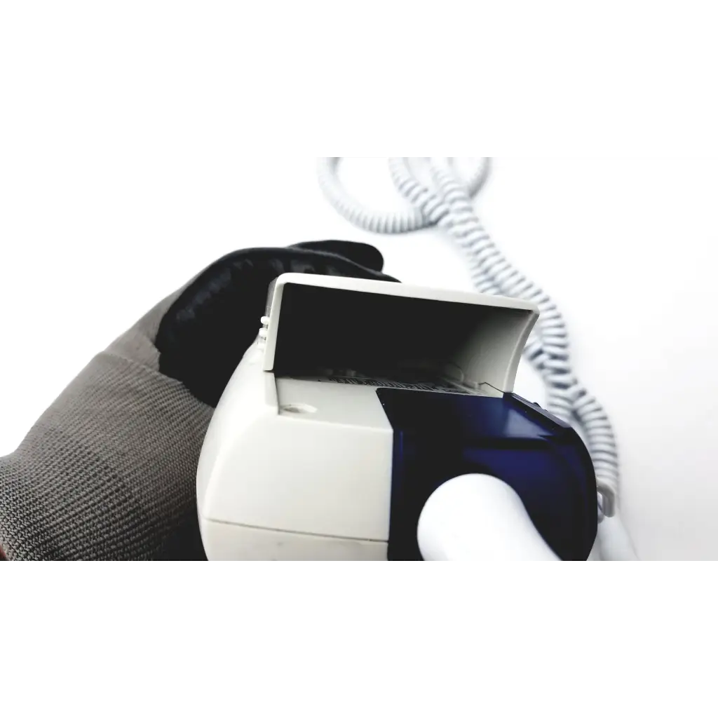 White and blue welch allyn suretemp plus thermometer with coiled cord held in a gloved hand for accurate readings