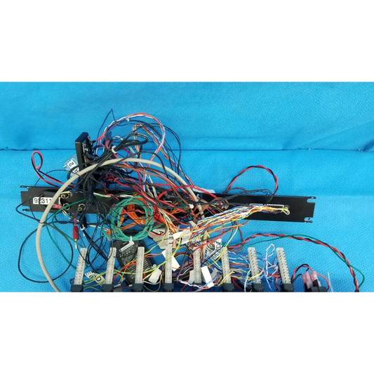 Back side of 19-inch rackmount control panel interface chassis with multicolored wire harness on black bracket