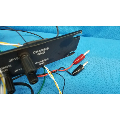Black plastic chassis ground plate with labeled connectors and wires on the back of 19-inch rackmount control panel interface