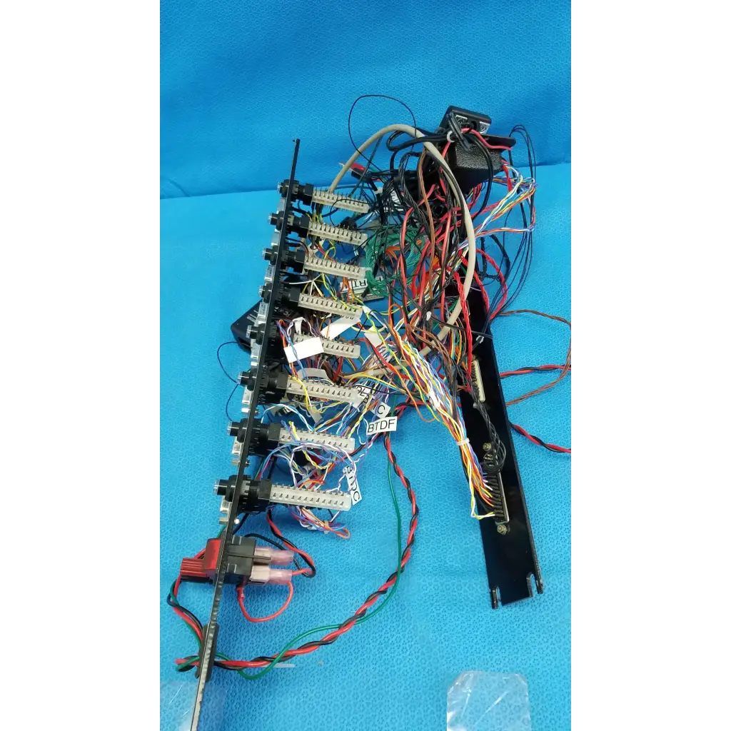 Black 19-inch rackmount control panel interface chassis with multiple connectors and colorful wire harness backside view