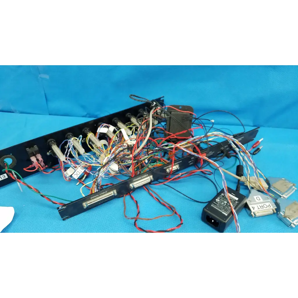 Black 19-inch rackmount control panel interface chassis with colorful wire harness cables on the back side