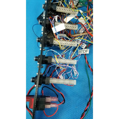 Black 19-inch rackmount control panel interface chassis with multiple connectors and colorful wire harness on back side