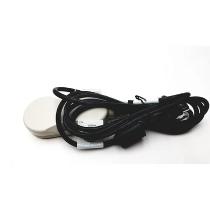 Black coiled power cable with 3-pin connector allows connection to bed’s control box next to off-white circular device