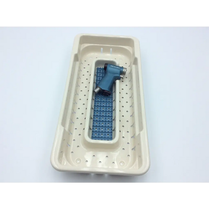 Blue microaire surgical instruments drill handpiece resting in beige perforated sterilization tray molded compartments