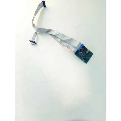 A flexible gray ribbon cable with blue connector and black caps attached to a green circuit board bbcb3-8c 22523sm