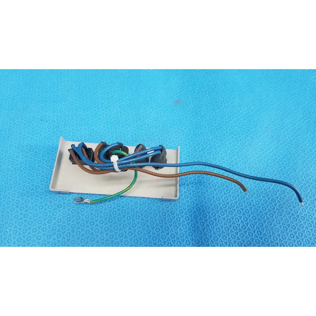 White rectangular power input plate assembly with fuse holder and bundled blue brown green wires secured by zip tie