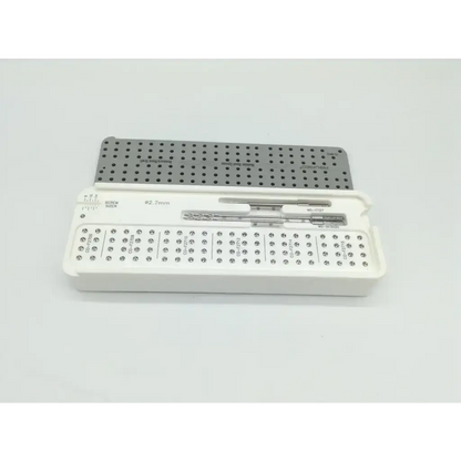 White plastic case holding acumed pl-wf01 acumed modular hand surgical drill bits and perforated metal plate with size markings