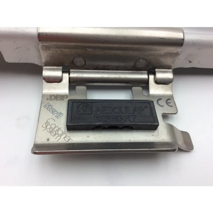 Stainless steel latch with black rubberized aesculap germany label on aesculap jn340 instrument sterilization container tray