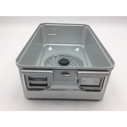 Silver metallic camping stove with circular mesh burner and black knob in aesculap jn742 sterilization case surgical