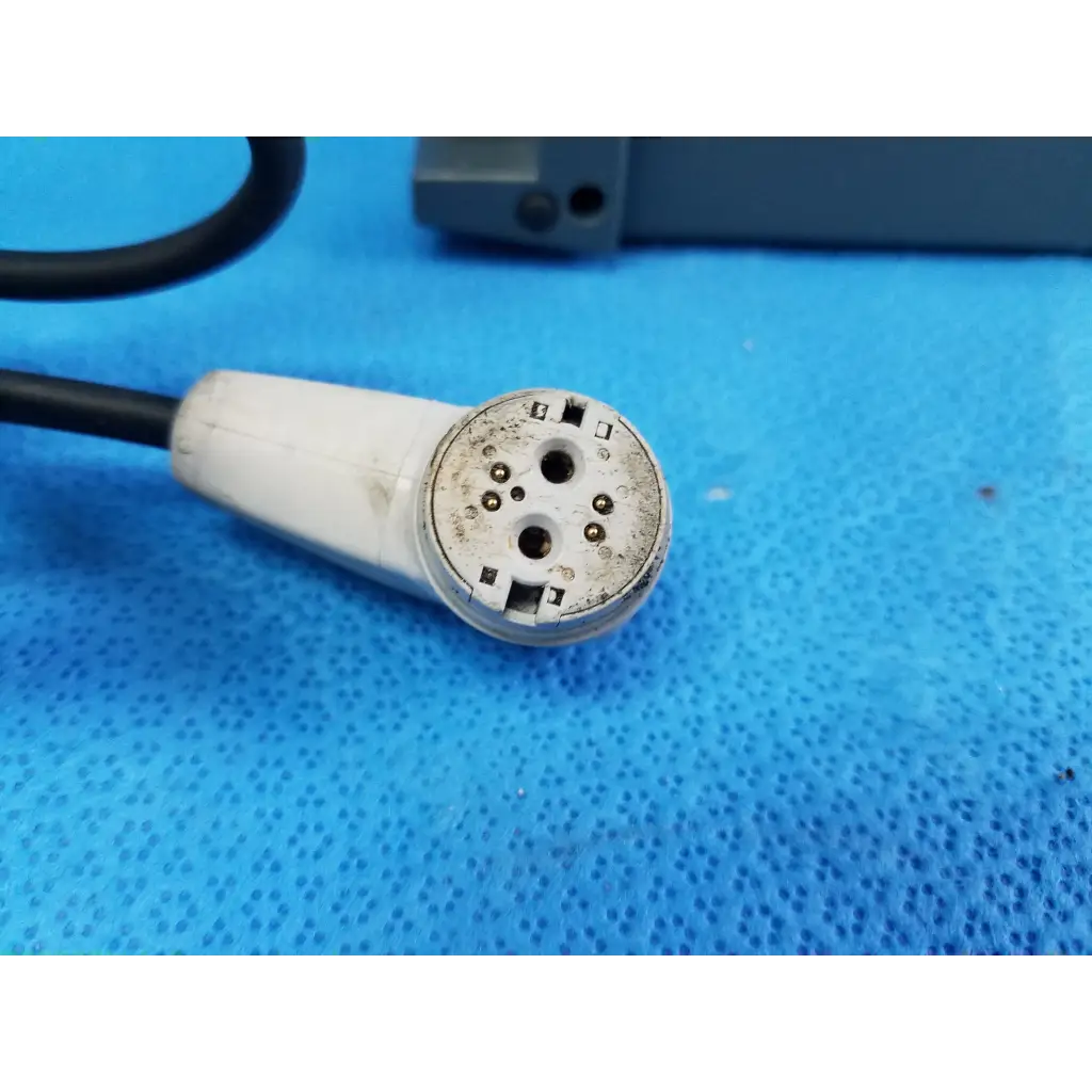 White plastic connector with metal pins and black cable showing wear on the back of alber e-fix viamobil power supply