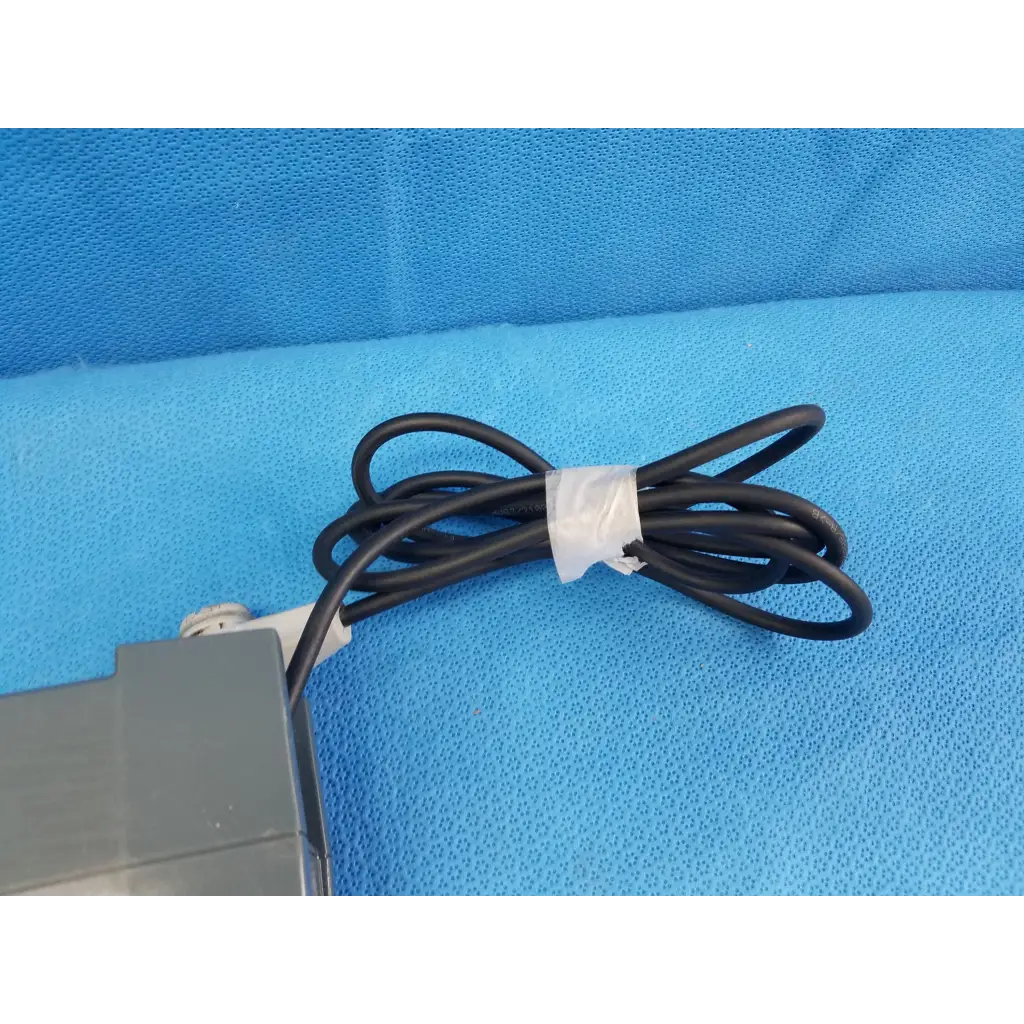 Black coiled power cable with white tie connected to gray alber e-fix viamobil ps4515 power supply battery charger