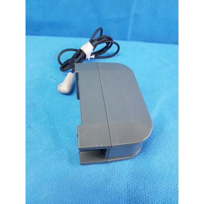 Gray plastic foot pedal with black coiled cable and white connector for alber e-fix viamobil power supply charger