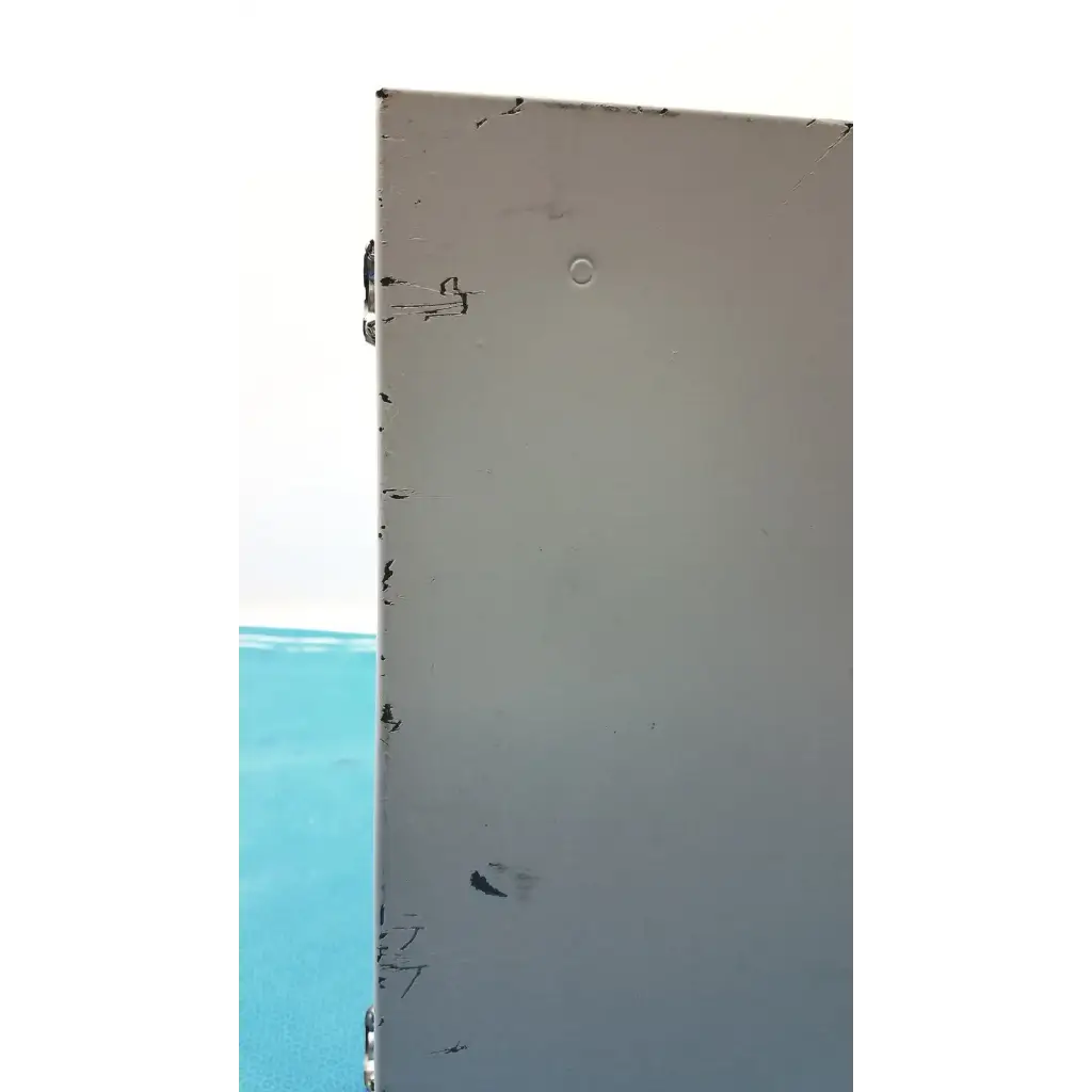 A weathered light gray metal panel with scratches and a small hole on the back of the altronix al400ulx power supply