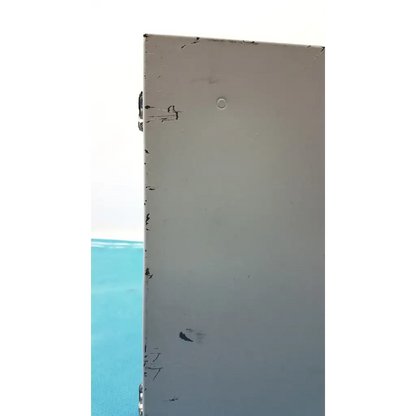 A weathered light gray metal panel with scratches and a small hole on the back of the altronix al400ulx power supply