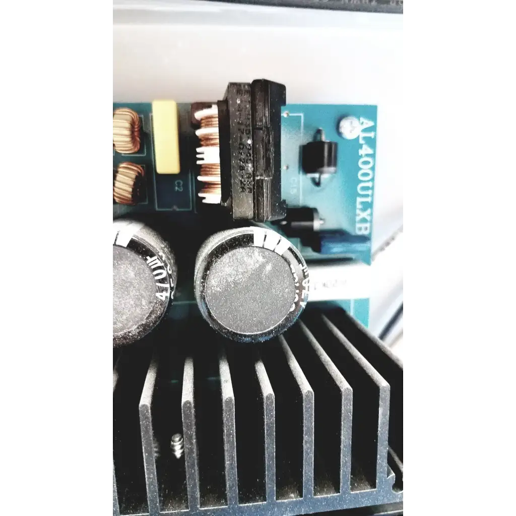Black cylindrical capacitors with silver tops on a black heat sink in the altronix al400ulx power supply charger