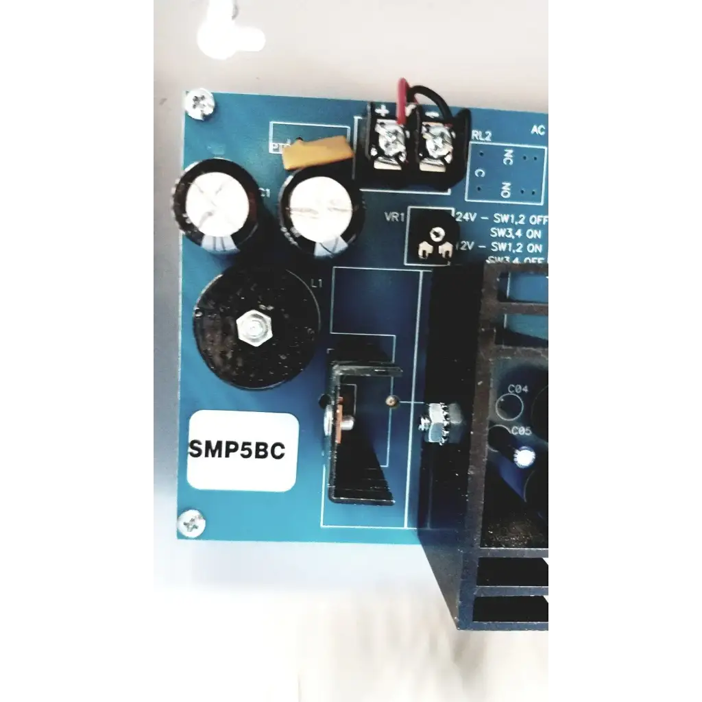 Blue printed circuit board with black capacitors and screws of altronix smp5ctx high current power supply charger