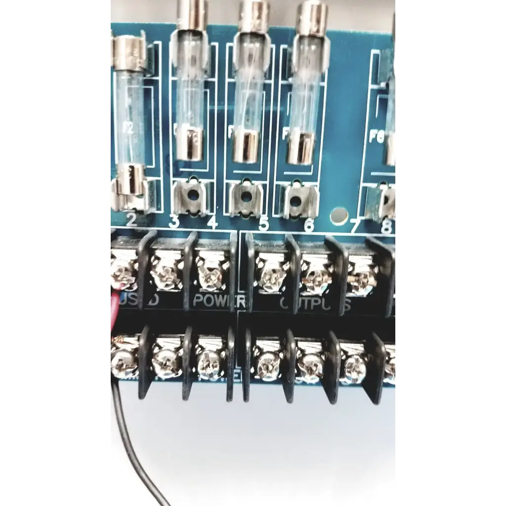 Blue circuit board of altronix smp5ctx high current power supply with clear glass fuse holders and silver metal terminals