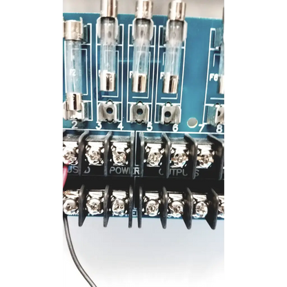 Blue circuit board of altronix smp5ctx high current power supply with clear glass fuse holders and silver metal terminals