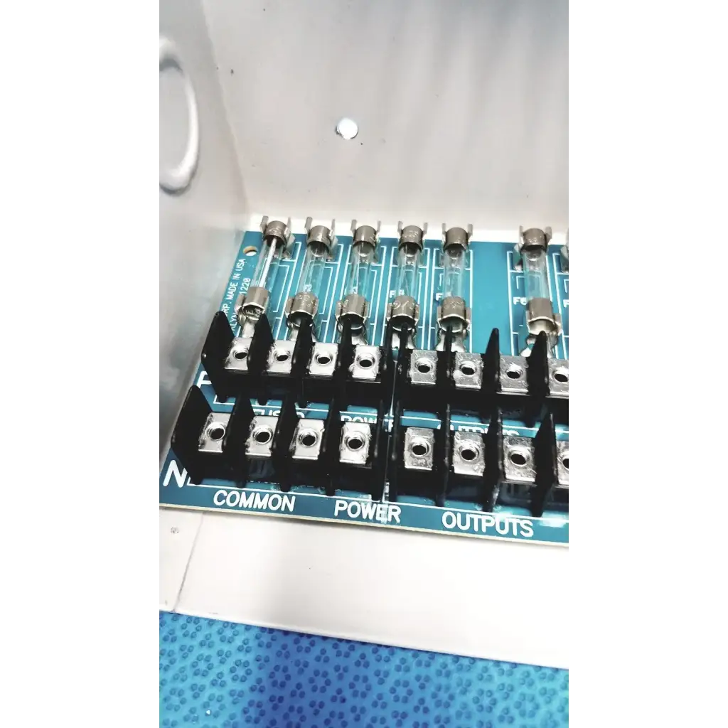 Blue circuit board with black terminal blocks and glass fuses in altronix smp5ctx high current power supply charger