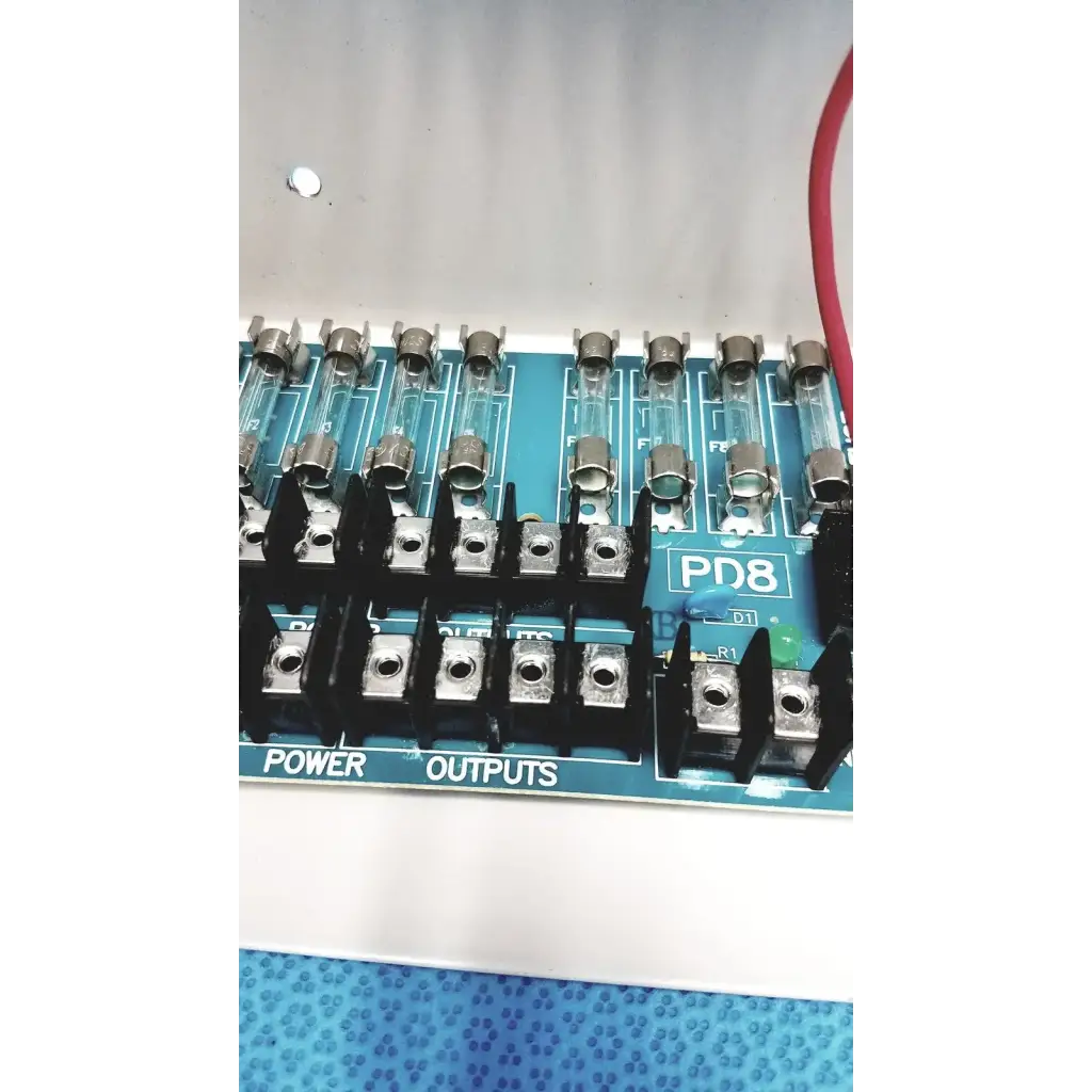 Blue pd8 power distribution board with black terminal blocks and glass fuses for altronix smp5ctx high current supply