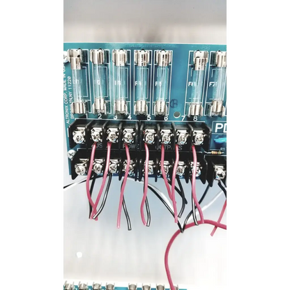 Blue circuit board of altronix smp5ctx high current power supply with eight glass fuses and red and black wire connections