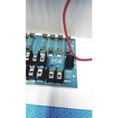 Blue pd8 circuit board with glass fuses and black terminal blocks in altronix smp5ctx high current power supply charger