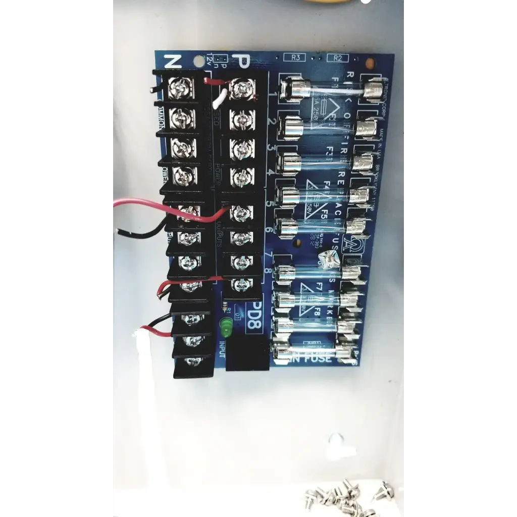 Blue circuit board with black terminal blocks and clear glass fuses in altronix smp5ctx high current power supply