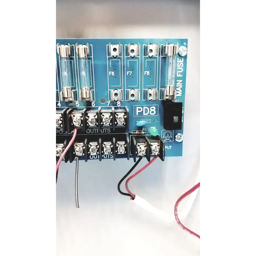 Blue pd8 main fuse panel with clear glass fuses and silver terminal blocks on altronix smp5ctx power supply charger