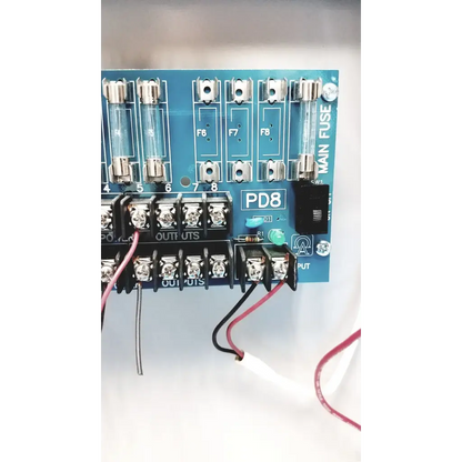 Blue pd8 main fuse panel with clear glass fuses and silver terminal blocks on altronix smp5ctx power supply charger