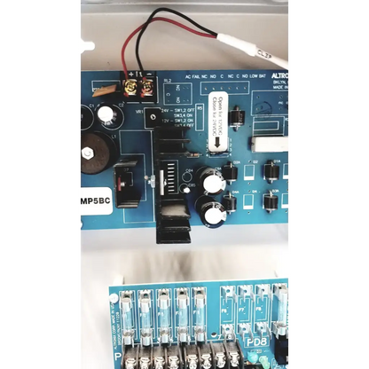Blue circuit board of altronix smp5ctx power supply with black and white components for 12VDC or 24VDC charging
