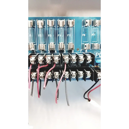 Blue circuit board of altronix smp5ctx power supply featuring glass fuses f1 to f8 and black terminal blocks with red black wires
