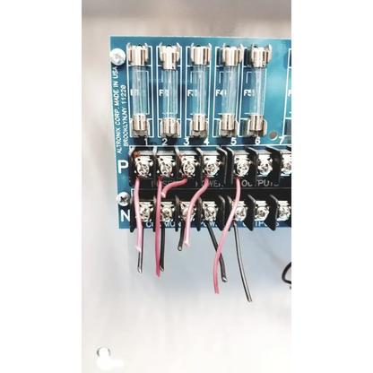 Blue altronix smp5ctx power supply circuit board with six glass fuses and black terminal blocks connected by pink and black wires