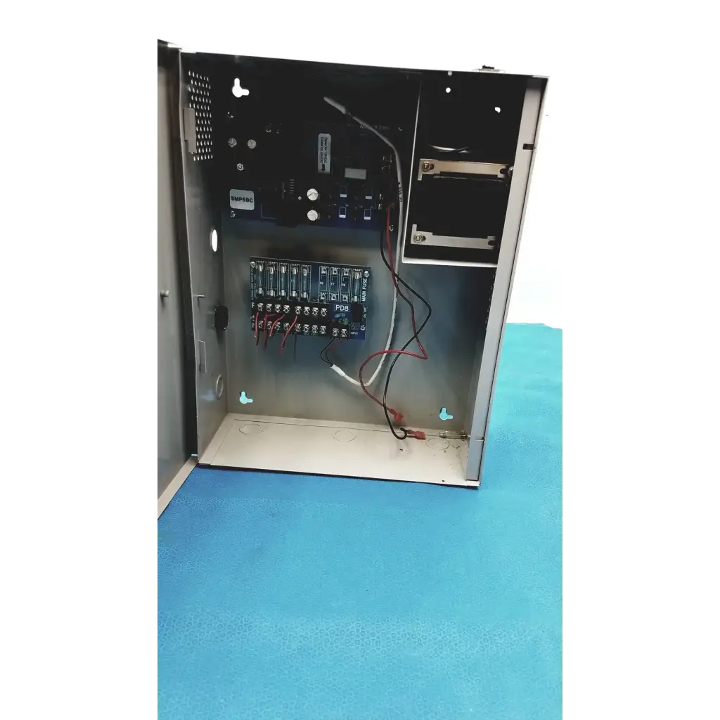 Metallic gray industrial control panel showing wiring and circuit boards inside for altronix smp5ctx power supply