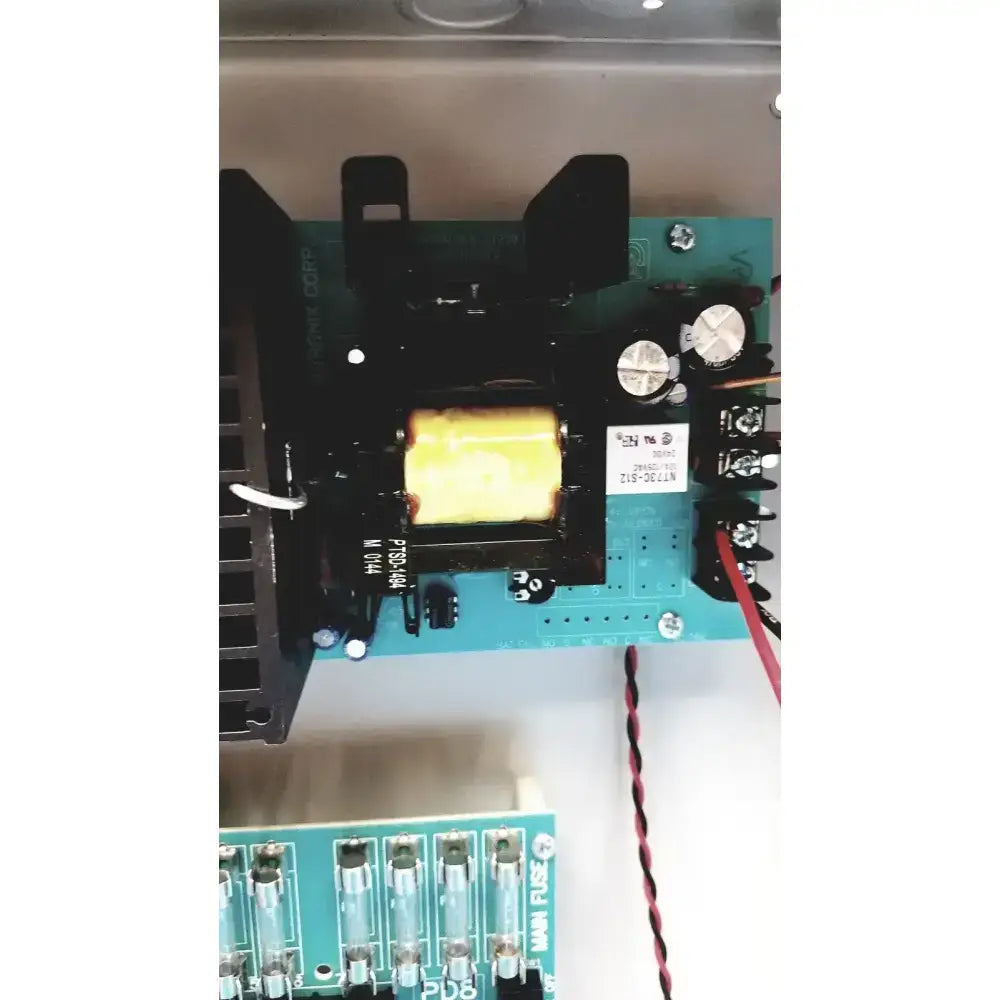 Black transformer with yellow core on a teal circuit board in altronix smp7-ctx high current power supply charger