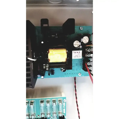 Black transformer with yellow core on a teal circuit board in altronix smp7-ctx high current power supply charger