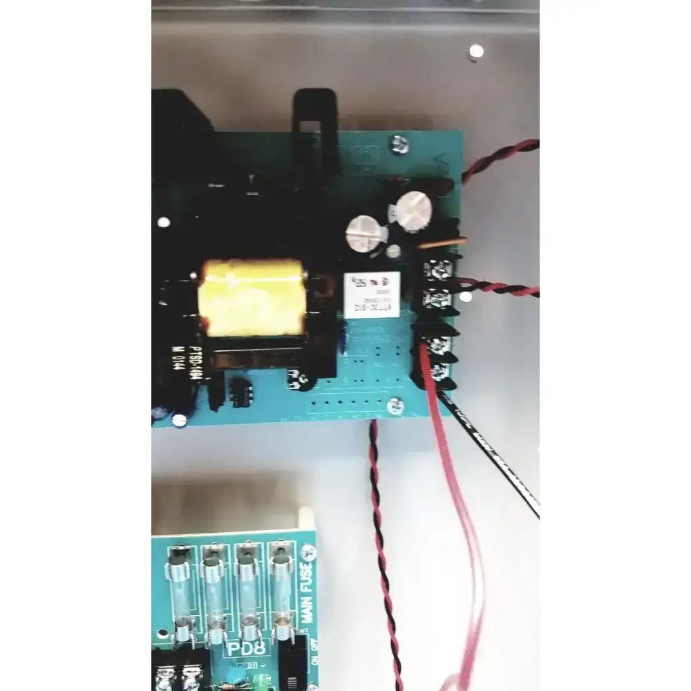 Teal-colored circuit board with black components silver knobs and red and black wiring in altronix smp7-ctx high current power supply