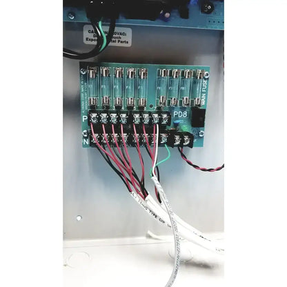 Green circuit board with glass fuse holders and labeled terminals on the back of altronix smp7-ctx high current power supply
