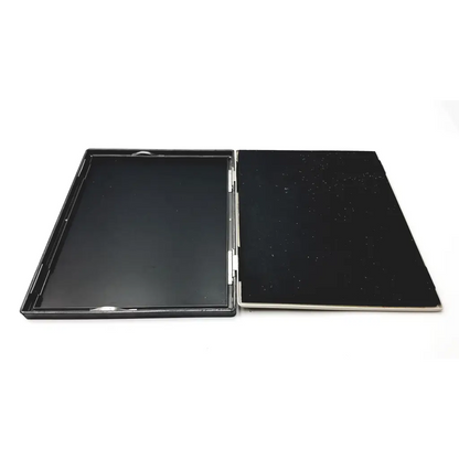 Black rectangular compact mirror with glossy finish and metallic hinge shown with amersham biosciences xray film hypercassette