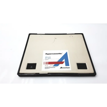Black-framed amersham biosciences xray film hypercassette with beige interior and white label featuring amersham logo