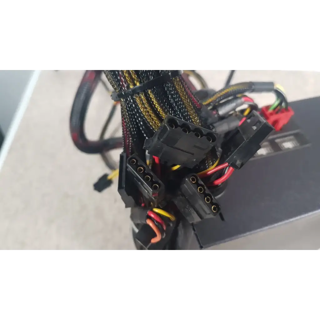 Black power supply cables with yellow and red wiring bundled by zip ties on the antec truepower 550w black unit