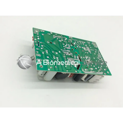 Green printed circuit board with silver solder joints and white components in artesyn nlp65-9910 ac-dc power supply