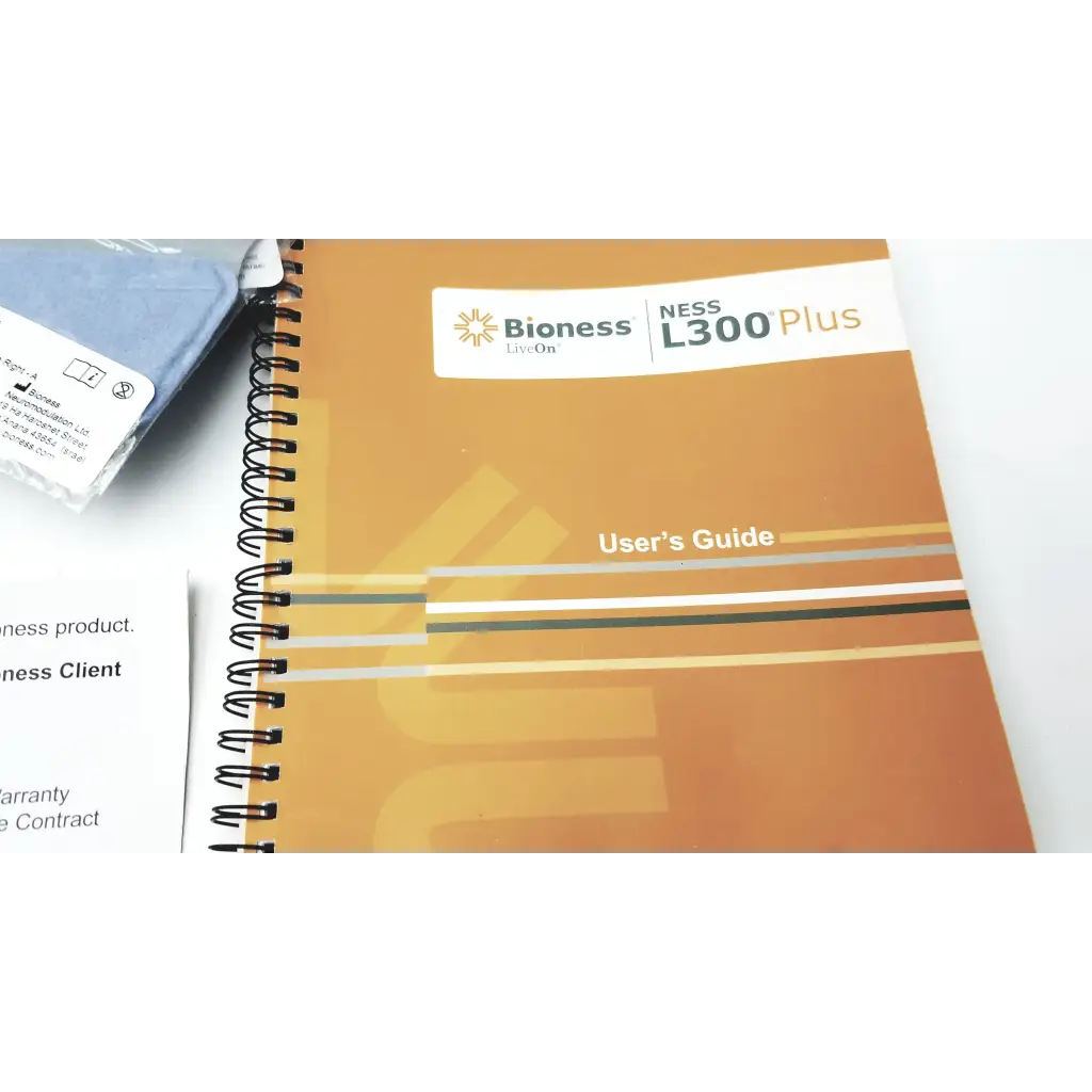 Orange spiral-bound user guide for bioness l300 plus thigh cloth electrodes showing front cover